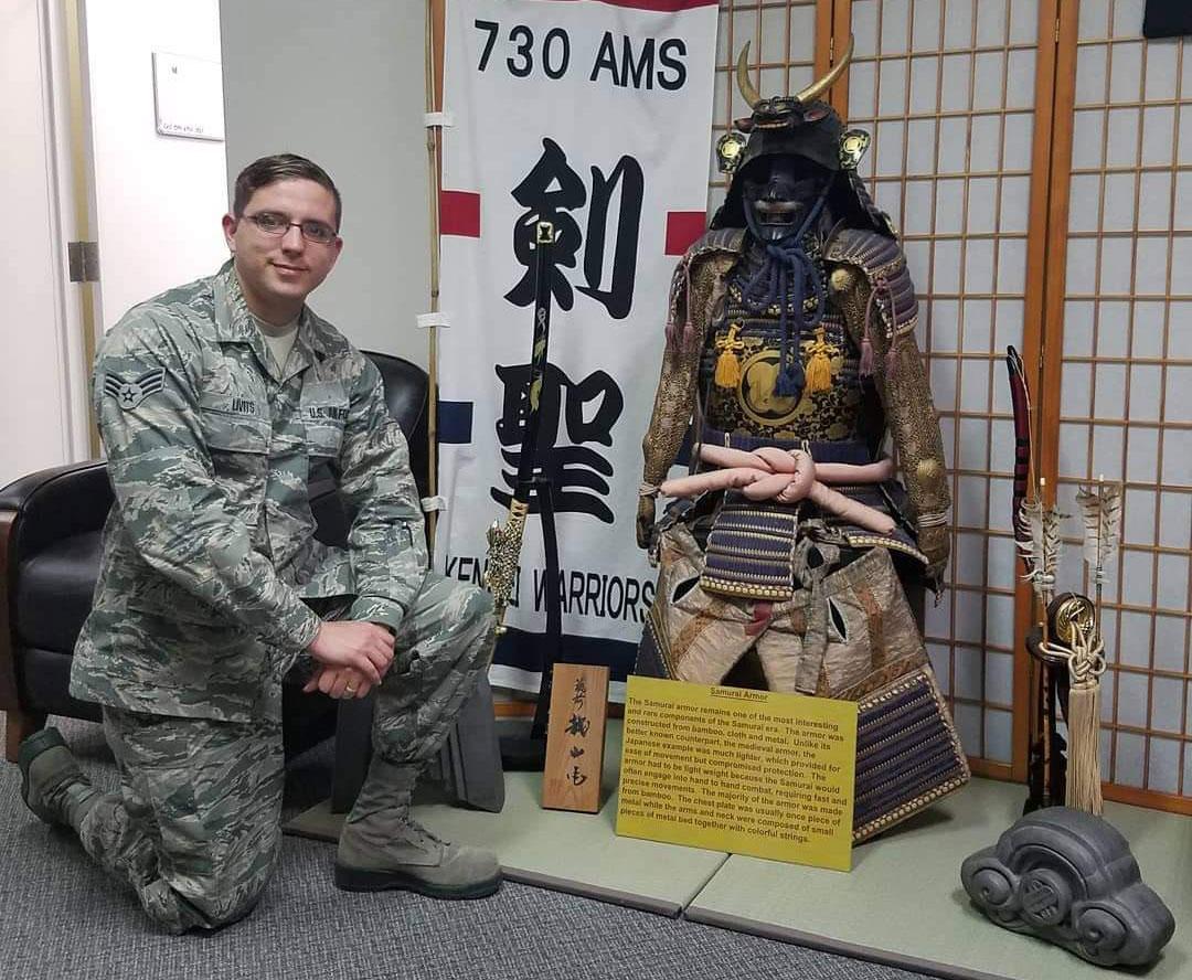 Lev kneeling next to Samurai armor